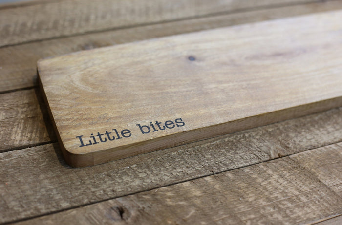 Wooden cutting board with 'Little bites' engraving on a wooden surface