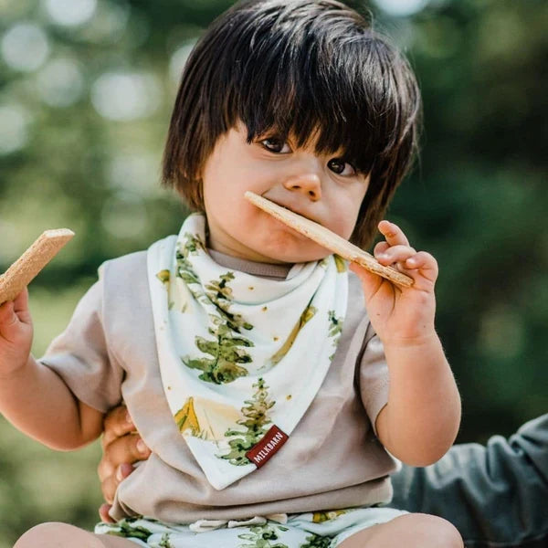 baby wearing bib in the woods