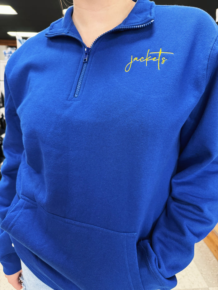 Blue pullover with 'jackets' embroidered on it, worn by a person.