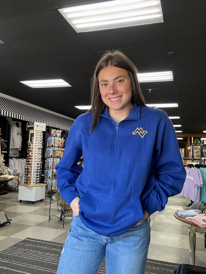Person wearing a blue hoodie with a logo in an indoor setting