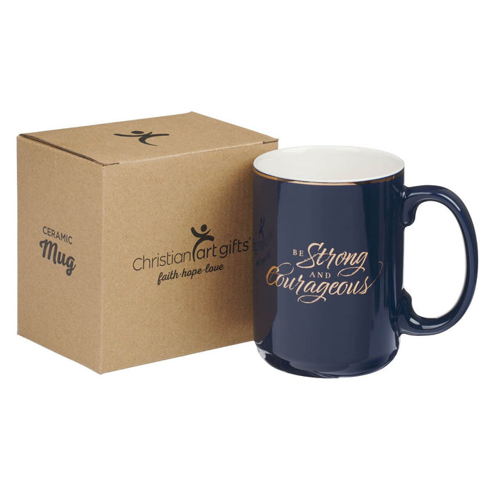 Navy blue mug with 'Be Strong and Courageous' text and matching box from Christian Art Gifts on a white background.