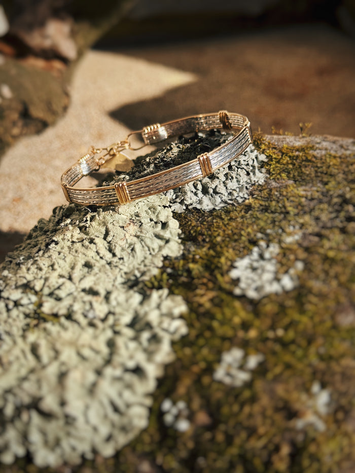 handmade straight wire bracelet on a mossy rock