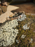 handmade straight wire bracelet on a mossy rock