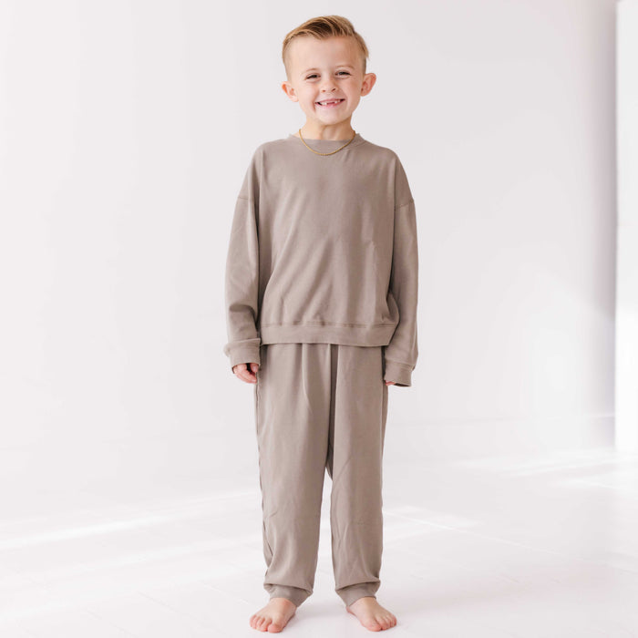Child wearing a beige pajama set on a white background