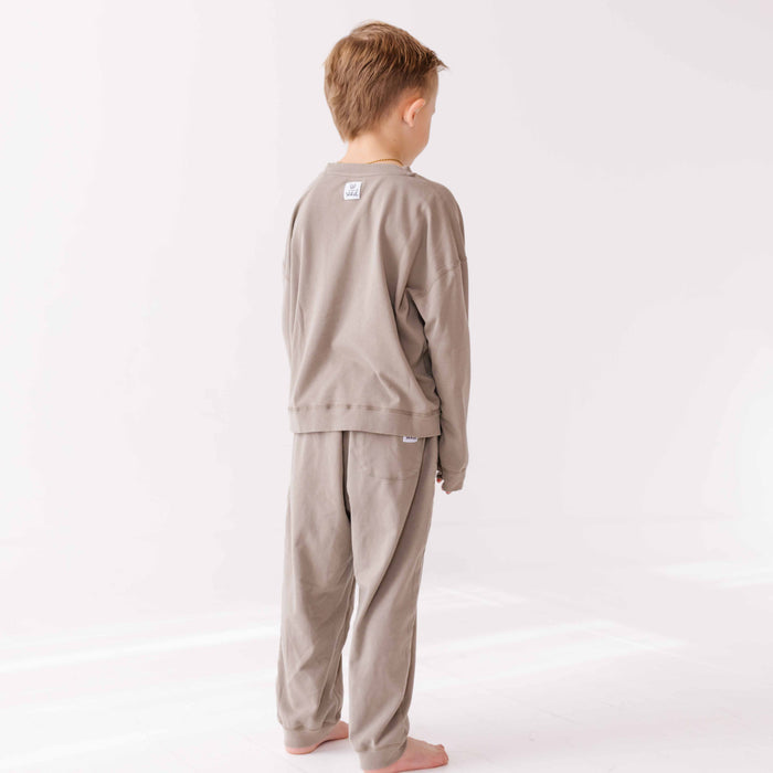 Child wearing a beige pajama set on a white background