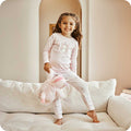 warmies unicorn pj set being worn by a child on a couch