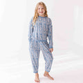 Young girl wearing a blue patterned pajama set on a white background